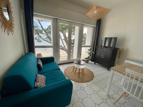 - un salon avec un canapé bleu et une table dans l'établissement Appartement vue mer île d'Oléron, à Saint-Trojan-les-Bains