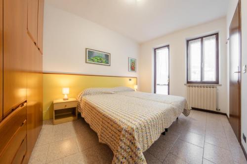 1 dormitorio con 1 cama y 1 mesa con lámpara en Casa Olga - Bilocale con terrazzo zona fiera en Verona