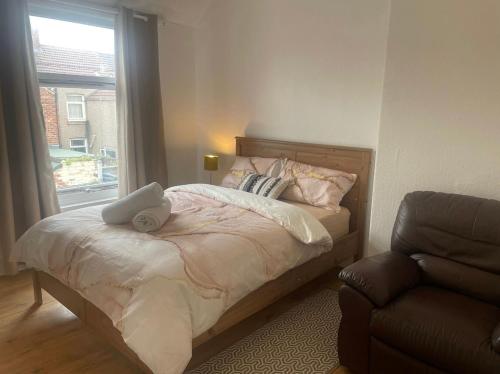 een slaapkamer met een bed, een stoel en een raam bij Beautiful Town Centre home in Middlesbrough
