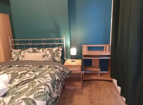 a bedroom with a bed and a desk with a lamp at Beautiful Town Centre home in Middlesbrough