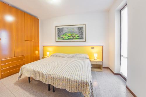 1 dormitorio con 1 cama y 1 mesa con 2 lámparas en Casa Olga - Bilocale con terrazzo zona fiera, en Verona