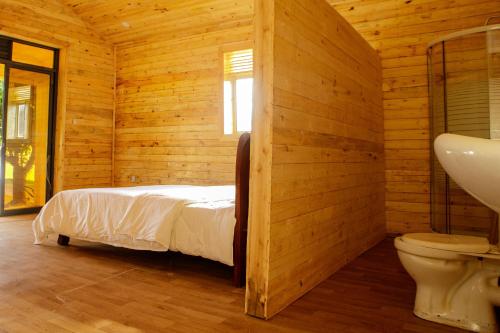 a bedroom with a bed in a wooden wall at Maravilla Kivu Eco Resort 