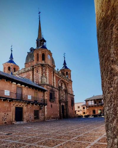 un edificio antiguo con una torre de reloj en un patio en Casa Doña Gumersinda, en San Carlos del Valle