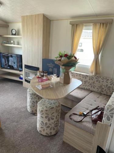 a living room with a table and a couch at 6 berth caravan Cherry tree holiday park Great yarmouth in Belton