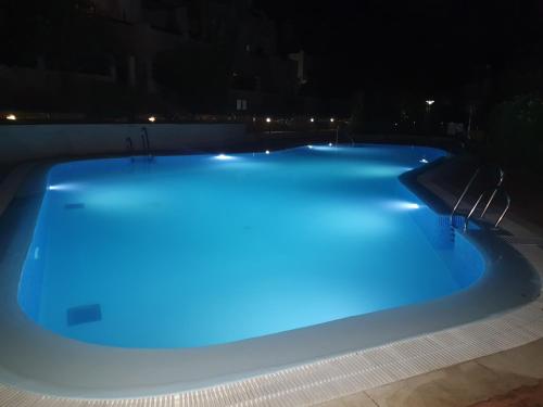 una piscina iluminada por la noche en Sara green house, en Sevilla