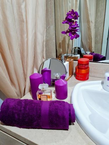 a bathroom with purple towels and a sink and a mirror at Sara green house in Seville