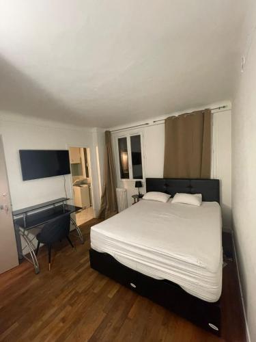 a bedroom with a bed and a desk in it at Auberge de l’Europe in Ivry-sur-Seine