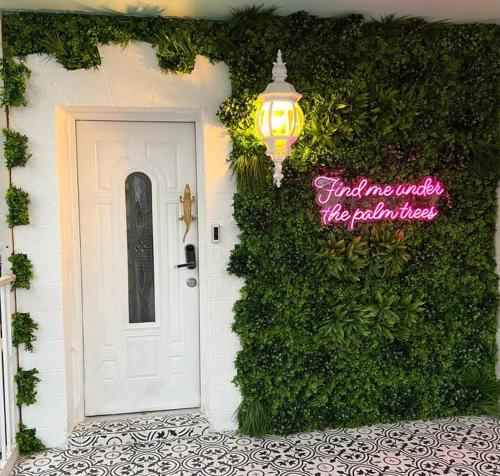 a white door with a sign on the side of a building at The Golden Alligator 2 - 3 beds 1 bath Palm Beach Regency style, near everything in West Palm Beach