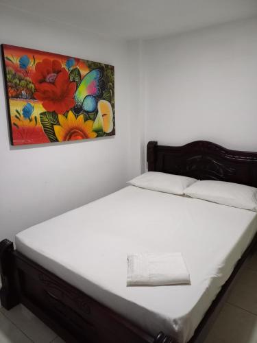 Bett in einem Zimmer mit Wandgemälde in der Unterkunft Hotel heliconias mompox in Mompós