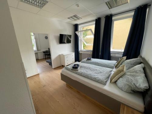 a bedroom with a bed and two windows at Smart In Göttingen - Apartments & Rooms in Göttingen