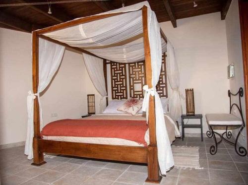 una camera con letto a baldacchino di Aurora Mari Villa Your Dream Steps from the Ocean Shore a Caleta De Fuste