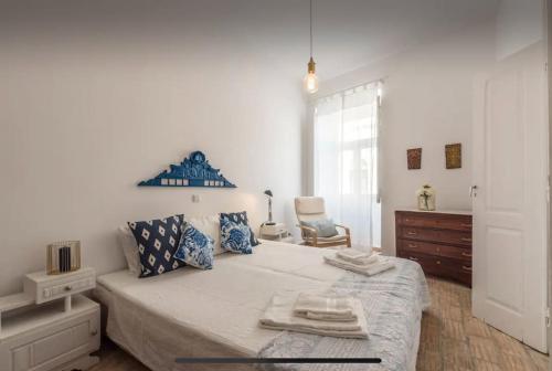a white bedroom with a large bed with towels on it at Traditional townhouse with private patio and pool in Portimão