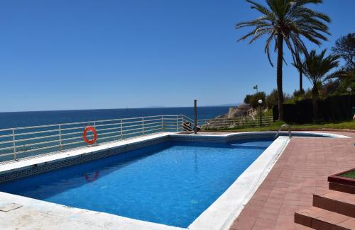 a swimming pool with the ocean in the background at 1a. Línea, vistas al mar, acceso directo a playa y piscina in Salou