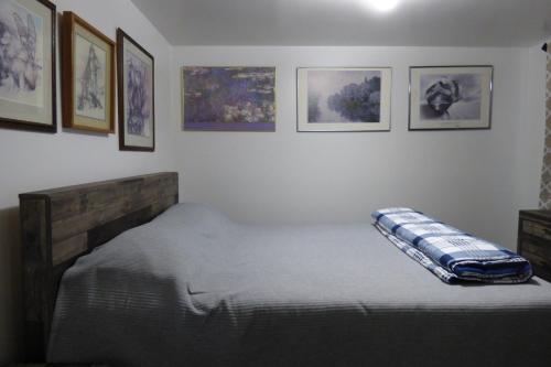 Bett in einem Zimmer mit Bildern an der Wand in der Unterkunft 410 E 45th #3 in Anchorage