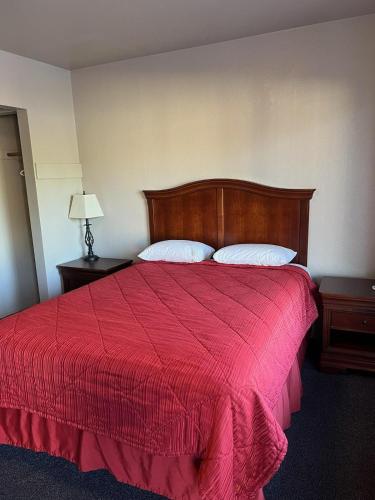 - une chambre avec un lit rouge et 2 oreillers dans l'établissement REGENCY INN, à Junction City