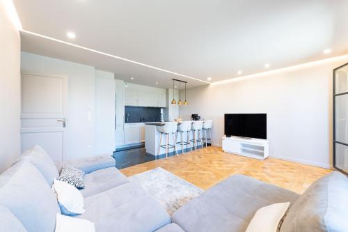 un salon avec un canapé et une cuisine dans l'établissement Prestige by Plaza, à Chessy