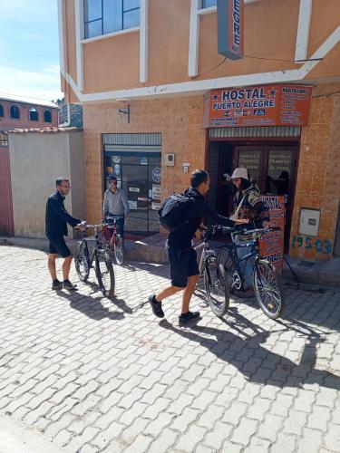 a group of men standing with their bikes on a street at Hostal Puerto Alegre in Copacabana