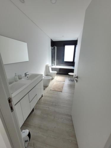 ein weißes Badezimmer mit 2 Waschbecken und 2 WCs in der Unterkunft Casa das Azorinas in Fenais da Luz