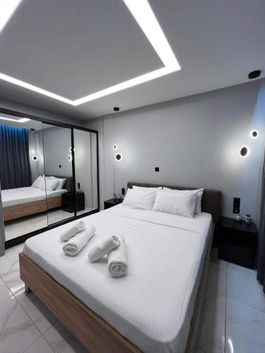 una camera da letto con un grande letto con due asciugamani di The Absolute Luxury Apartment a Kalamáta