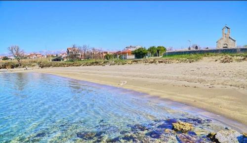 a view of a beach with a building in the background at Villa Pagar - with jacuzzi - Renovated in 2022 in Povljana