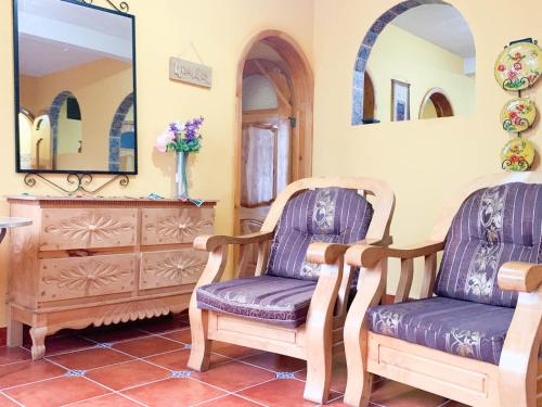 a room with two chairs and a dresser and a mirror at Casa Esperanza in Panajachel