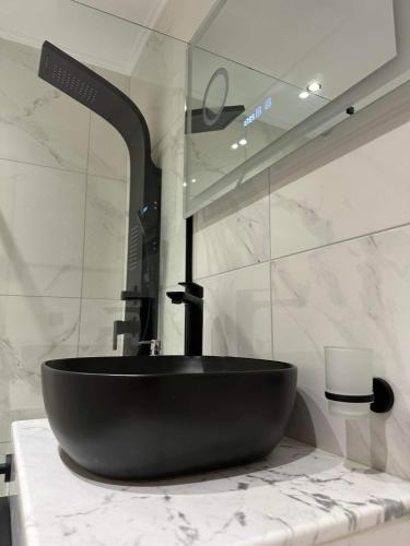 un bagno con lavandino nero su un bancone di The Absolute Luxury Apartment a Kalamáta