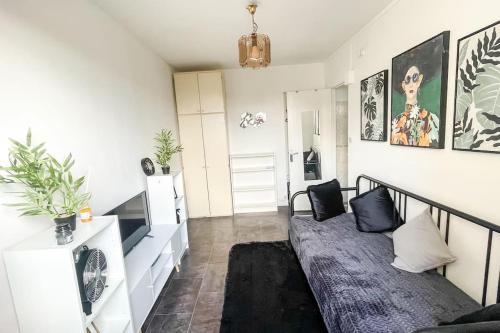 a living room with a couch in a room at Le Comfy Spot - Porte de Paris in Aubervilliers