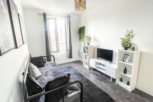 un salon avec un canapé et une télévision dans l'établissement Le Comfy Spot - Porte de Paris, à Aubervilliers