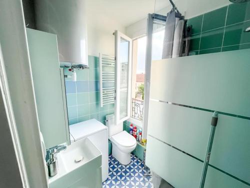 łazienka z toaletą, umywalką i oknem w obiekcie Le Comfy Spot - Porte de Paris w mieście Aubervilliers