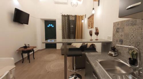 uma cozinha com um lavatório e uma bancada em Casa do Beco, confortável, em bairro típico de Olhão em Olhão