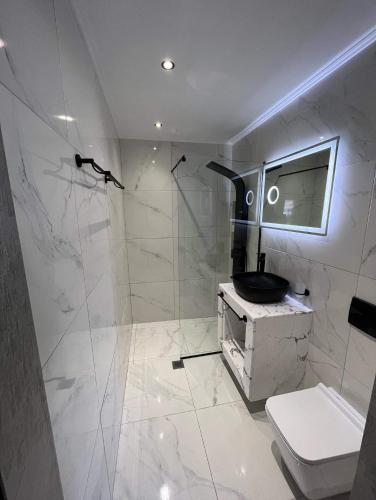 a bathroom with a shower with a toilet and a sink at The Absolute Luxury Apartment in Kalamata