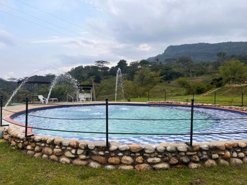 a swimming pool with a fountain in a park at casona torremolinos in Moniquirá