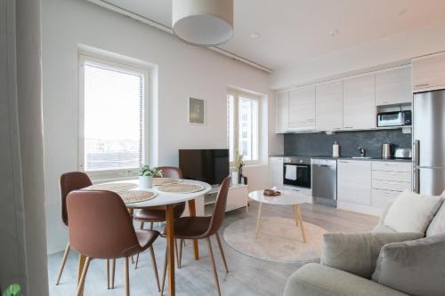 uma cozinha e sala de estar com mesa e cadeiras em City Apartment Matkatupa em Kuopio