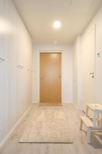 an empty hallway with a door and a rug at Pramea Apartments Matkatupa in Kuopio