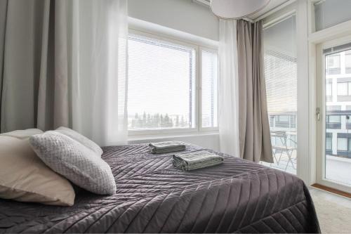 um quarto com uma cama com duas almofadas e uma janela em City Apartment Matkatupa em Kuopio