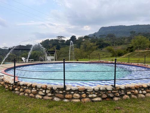 a swimming pool with a fountain in a park at Caney 1 in Moniquirá