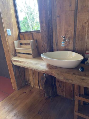 a bathroom with a white sink on a wooden counter at Las Casitas Italiana in Sabalito