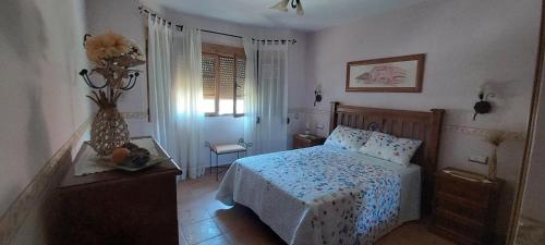 a bedroom with a bed and a table and a window at Casa Rural Rincones de Albares in Albares