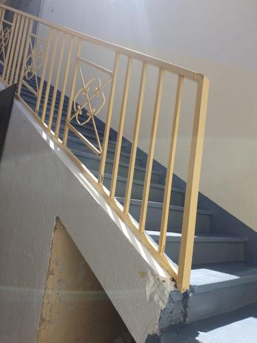 a staircase with a metal railing on a stair case at Bel appartement in Oujda