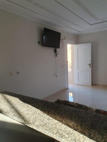 a white room with a flat screen tv on a wall at Bel appartement in Oujda
