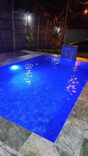 a swimming pool at night with blue water at Casa Bahía Ale, Bahía Ballena Uvita in Uvita