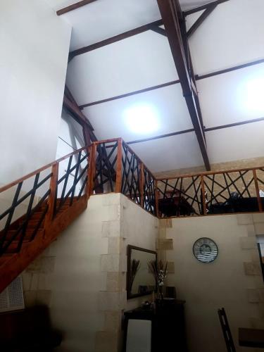 a wooden staircase in a building with a ceiling at Maison de charme aux grands volumes in Minzac