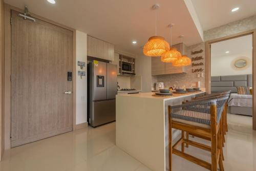a kitchen with a counter and a kitchen island in a room at Lujoso Apartamento Con Salida Directa A La Playa Edificio Morros Eco in Cartagena de Indias