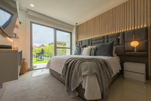 een slaapkamer met een groot bed en een groot raam bij Lujoso Apartamento Con Salida Directa A La Playa Edificio Morros Eco in Cartagena