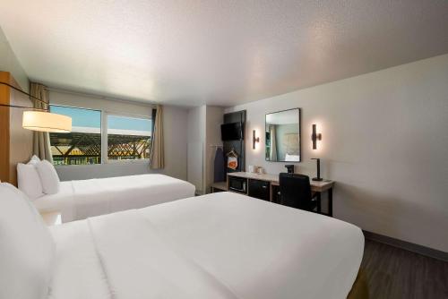 a hotel room with two beds and a desk and a mirror at Quality Inn Yuba City-Marysville in Yuba City