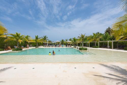 a swimming pool with palm trees and people in it at Lujoso Apartamento Con Salida Directa A La Playa Edificio Morros Eco in Cartagena de Indias