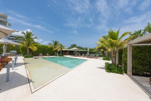 a swimming pool with palm trees and a resort at Lujoso Apartamento Con Salida Directa A La Playa Edificio Morros Eco in Cartagena de Indias