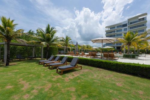 a group of lounge chairs and umbrellas in a yard at Lujoso Apartamento Con Salida Directa A La Playa Edificio Morros Eco in Cartagena de Indias