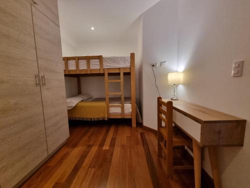 La Molina的住宿－Departamento estreno 2do piso，小房间设有一张桌子和一张双层床