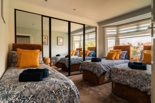a bedroom with two beds and a large mirror at Luxury Affordable Business Stay with Hot Tub and Pool Table in Enfield Lock